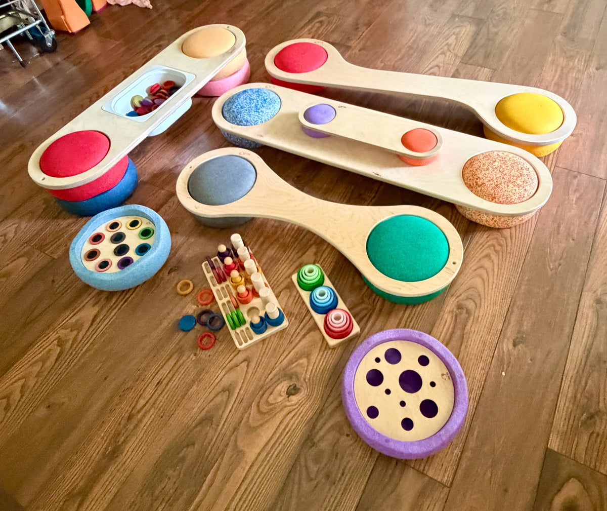 Maple Play balance boards and sensory inserts for Stapelstein stepping stones, overhead view on hardwood floor with Grapat loose parts