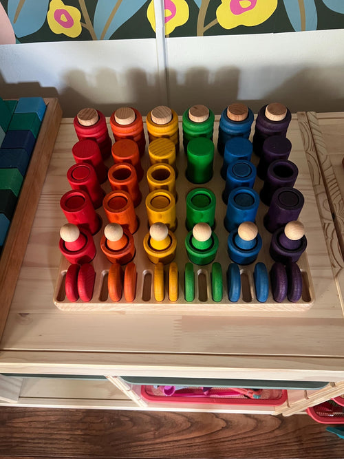 Wooden tray sitting on a shelf with colorful Grapat figures