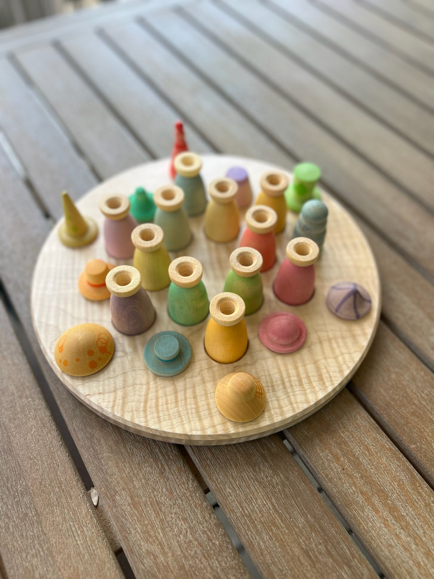 Colorful wooden toys on a round wooden board on a wooden surface