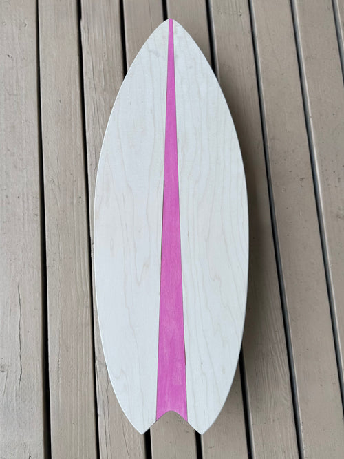 Wooden surfboard with a pink stripe on a wooden surface