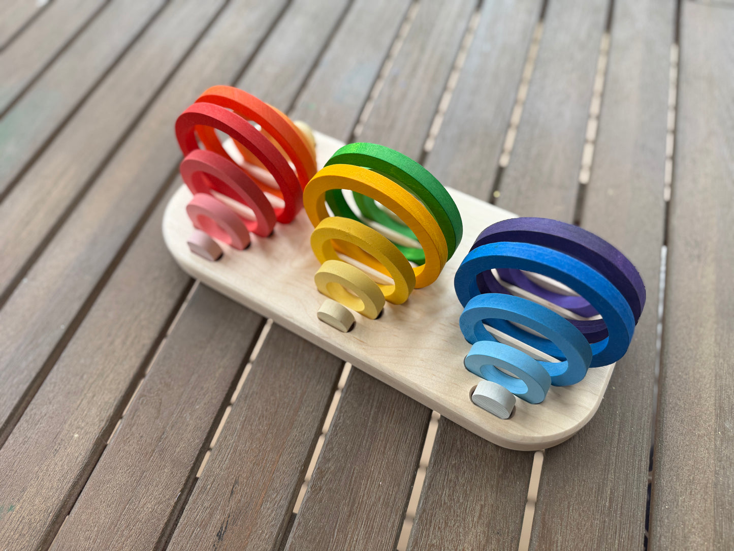 Wooden nest ring tray with rainbow nesting rings displayed upright