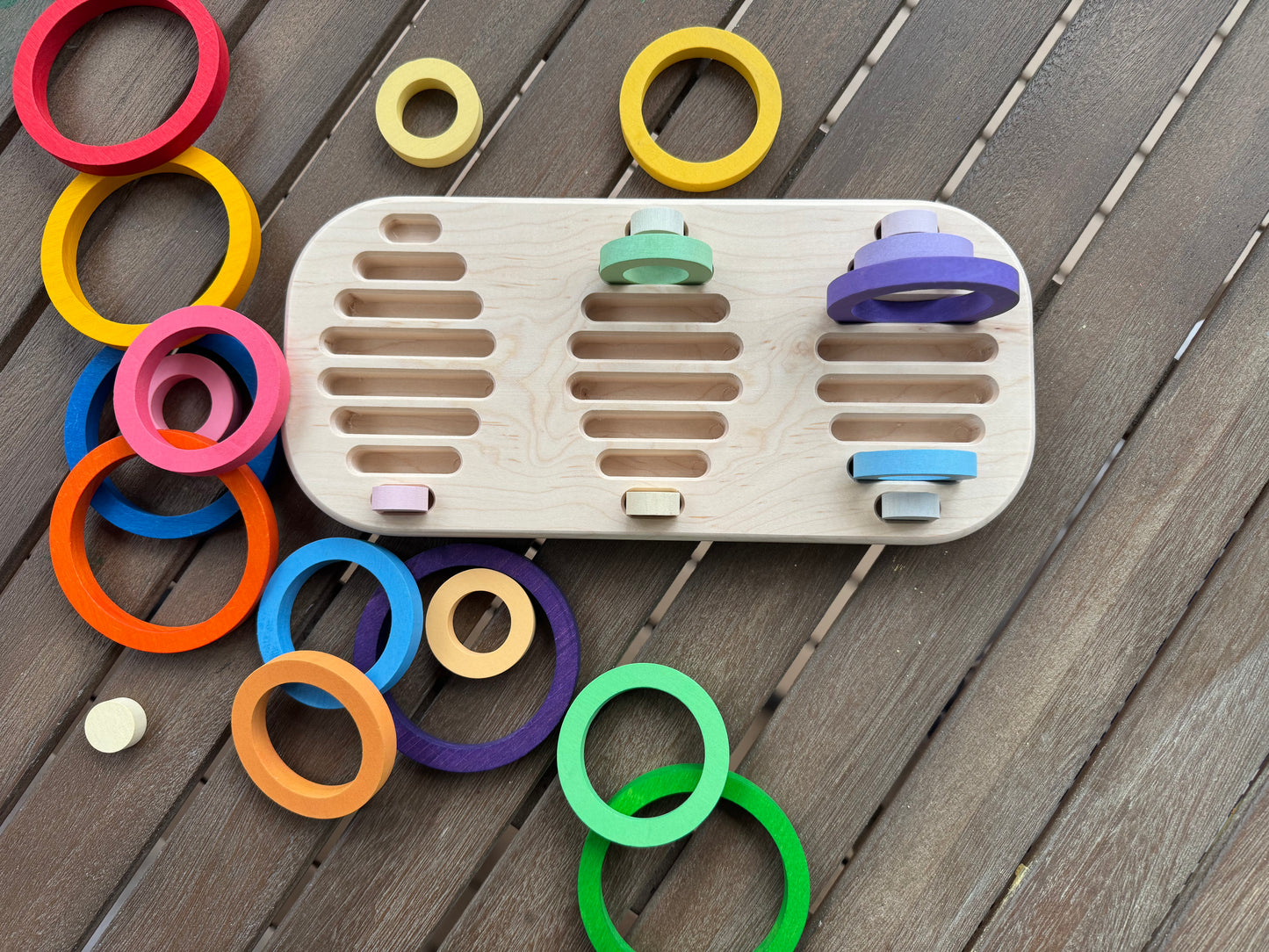 Wooden toy with colorful rings on a wooden handmade tray all spread out