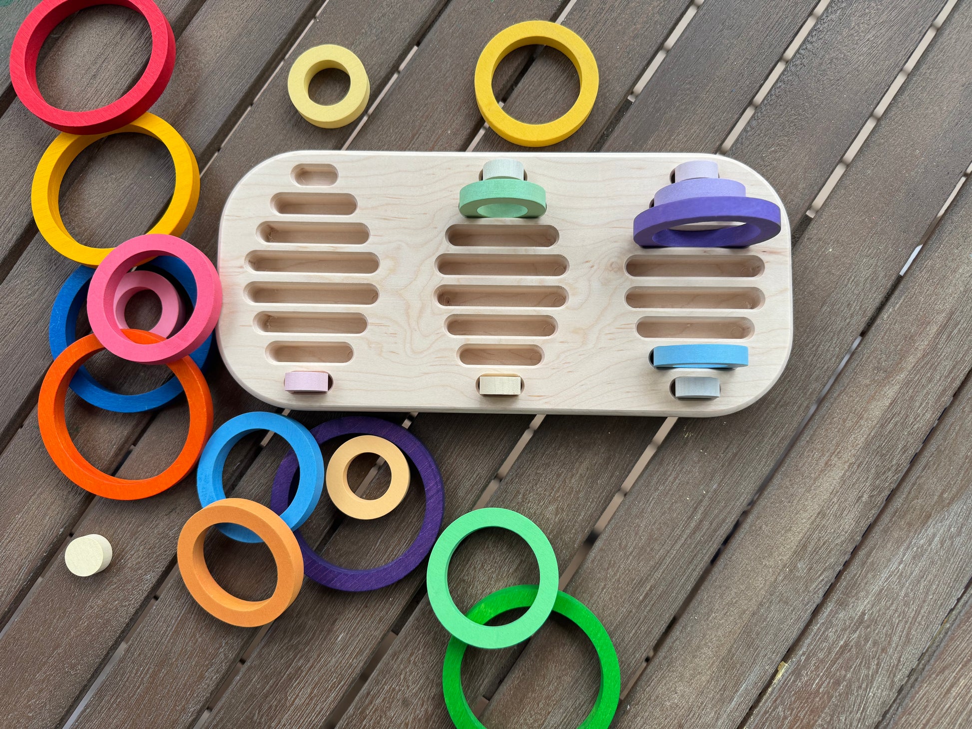 Wooden toy with colorful rings on a wooden handmade tray all spread out