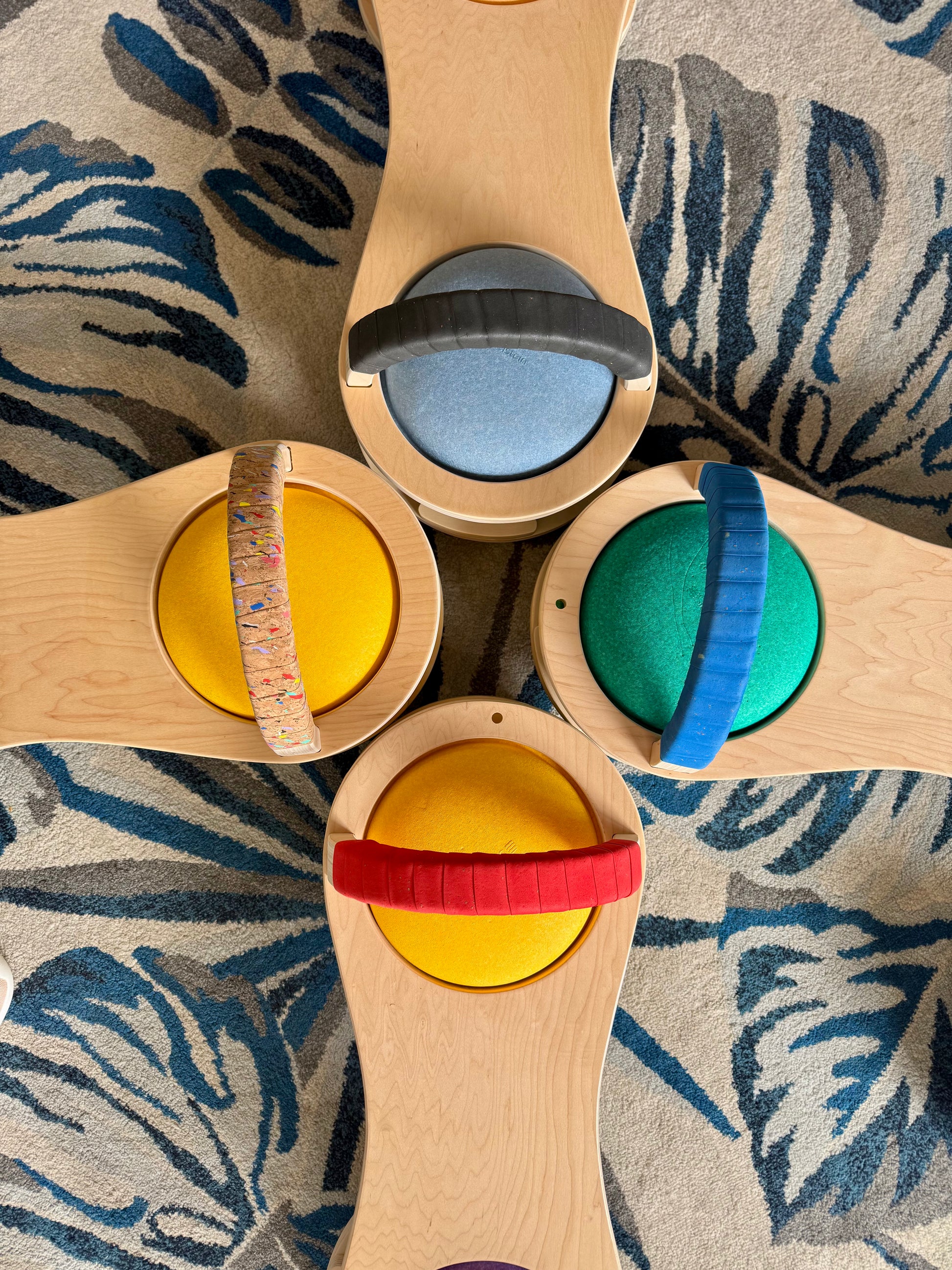Wooden toy with colorful lids on a patterned fabric background