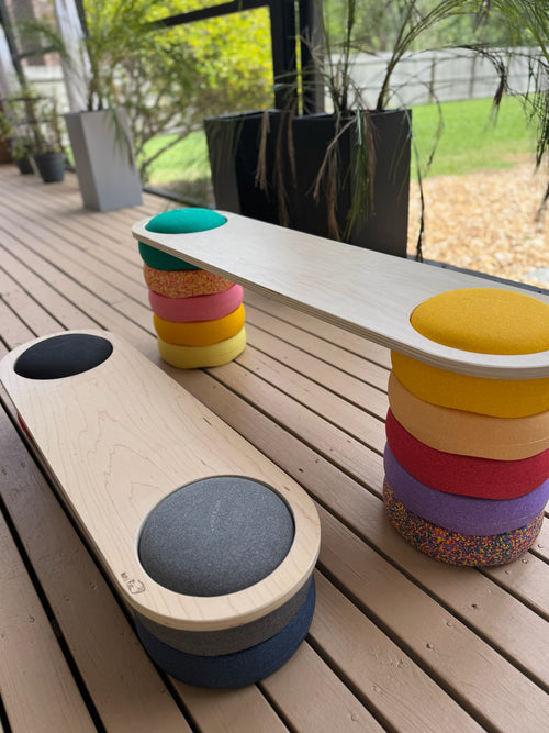 Colorful stackable stools on a wooden deck with outdoor background