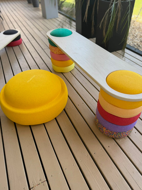 Colorful stackable stools on a wooden deck