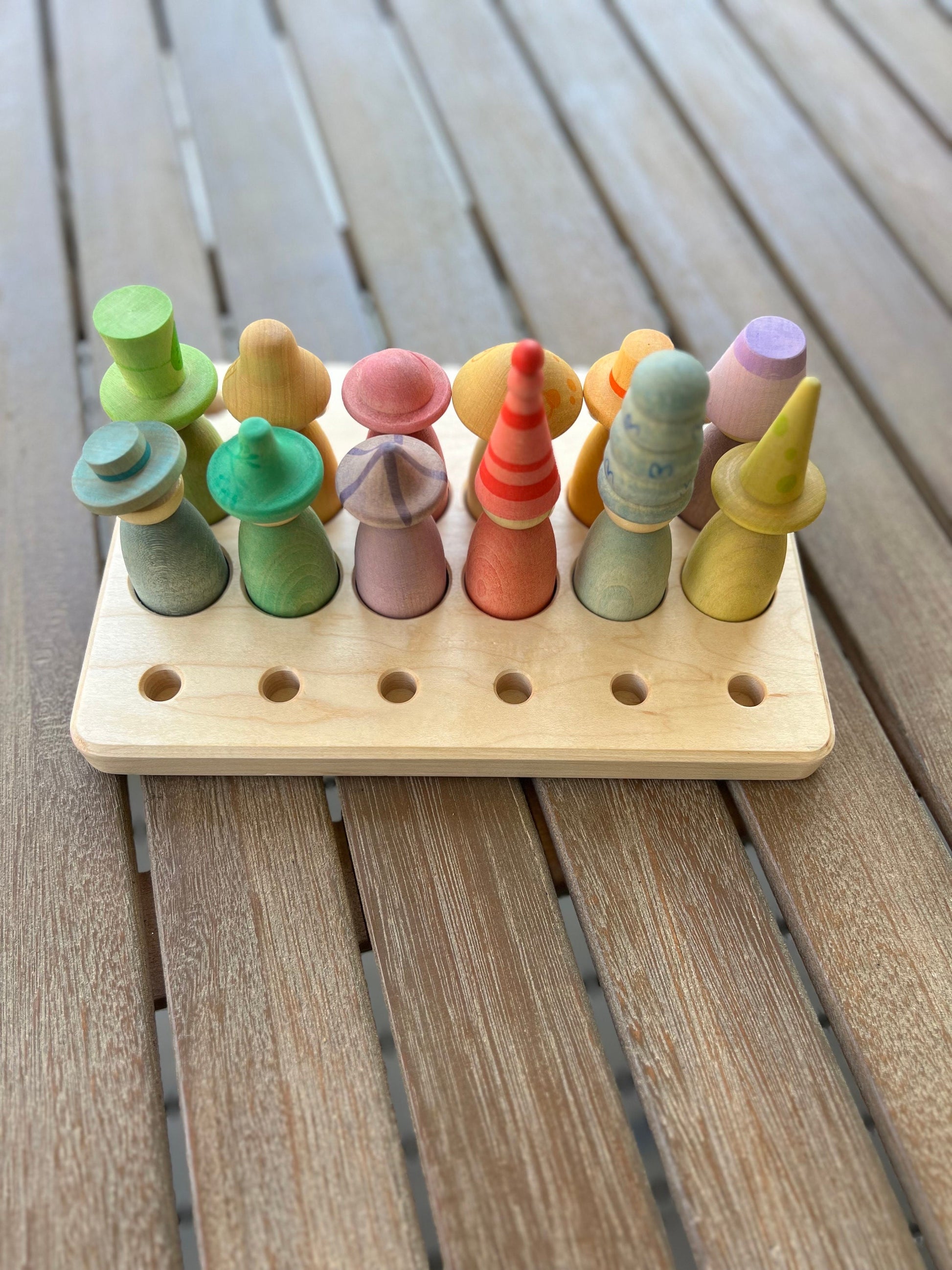A wooden sorting/storage tray with compartments, each containing a Grapat figures in various colors.