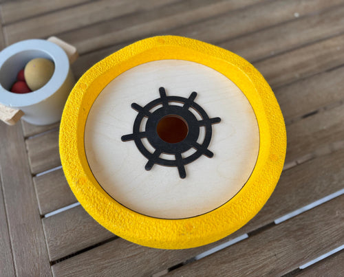 A wooden lid with one holes inside Stapelstein stepping stone 