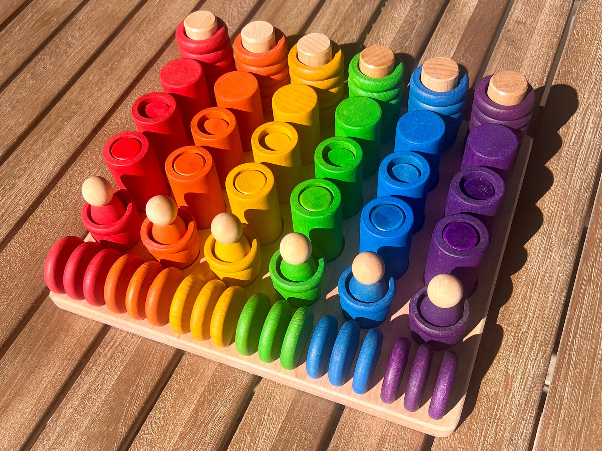 A wooden sorting tray with Grapat Nins Carla with Mates and Lola blocks arranged inside, showcasing a variety of bright colors.