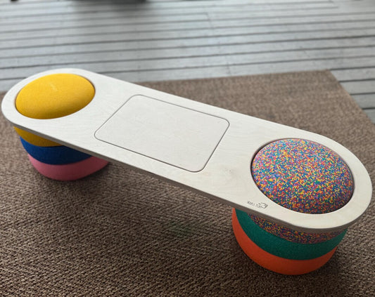 Handmade maple wood balance board for kids, on a carpet